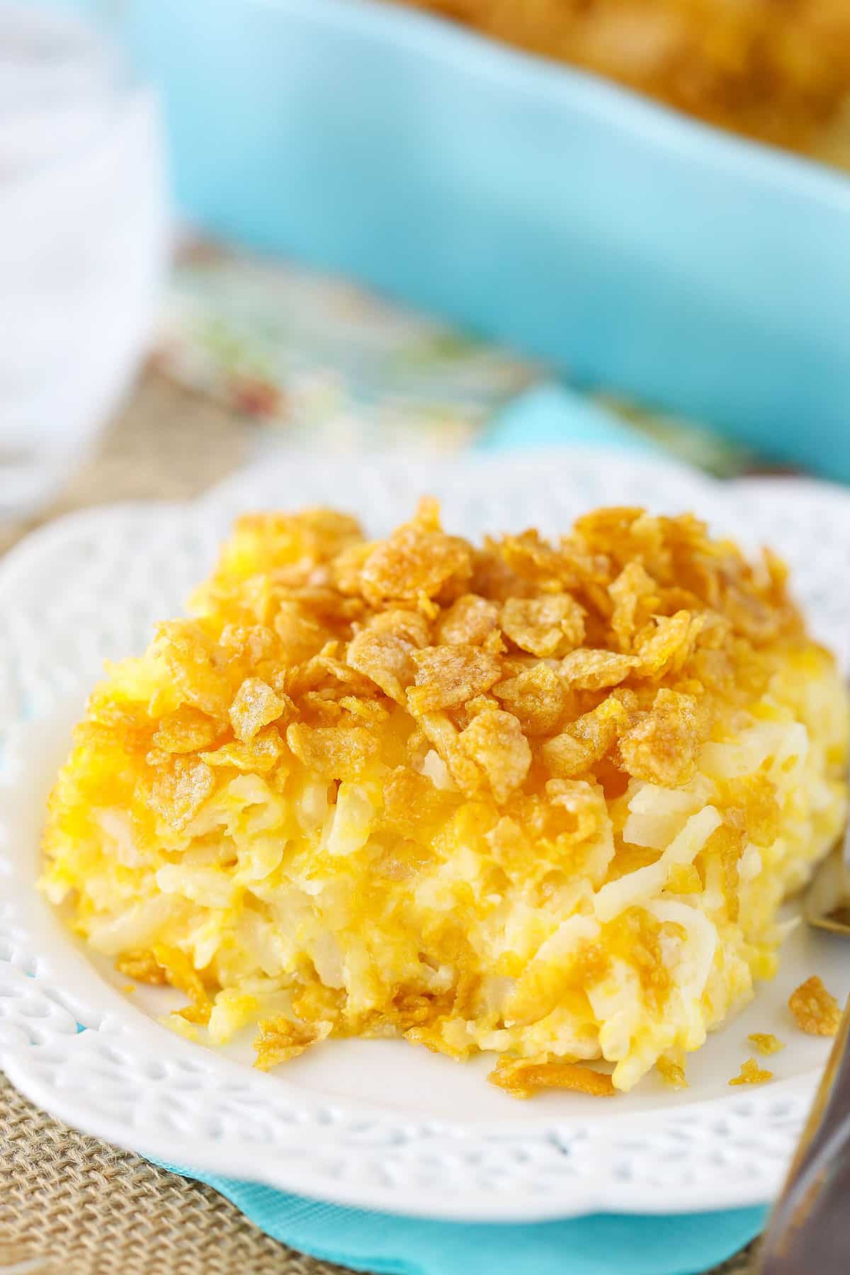 Covered in a crunchy and buttery cornflake topping, this cheesy hashbrown casserole is a super easy breakfast bake that always hits the spot! It also makes a wonderful side dish for the holidays! Plate of cheesy hashbrown casserole with crushed cornflakes.