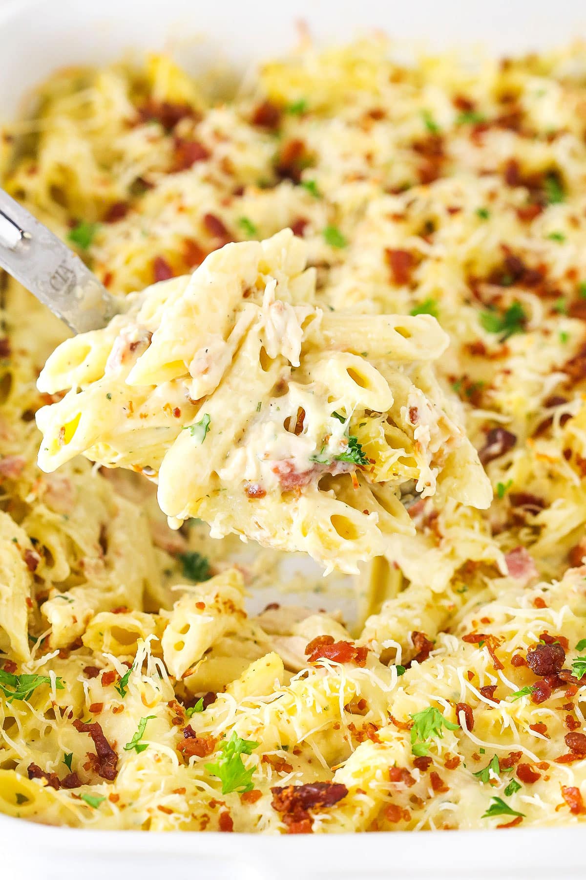 Creamy, cheesy, and comforting, this chicken bacon ranch casserole will be out of the oven in 20 minutes. It's the perfect weeknight dinner. Close-up of chicken bacon ranch casserole with melty cheese.