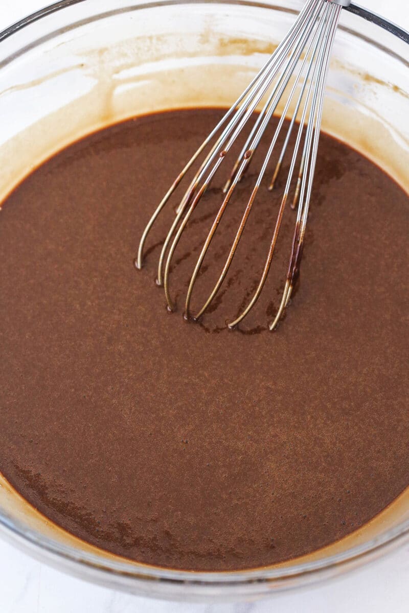 Mixing hot water into chocolate cupcake batter.