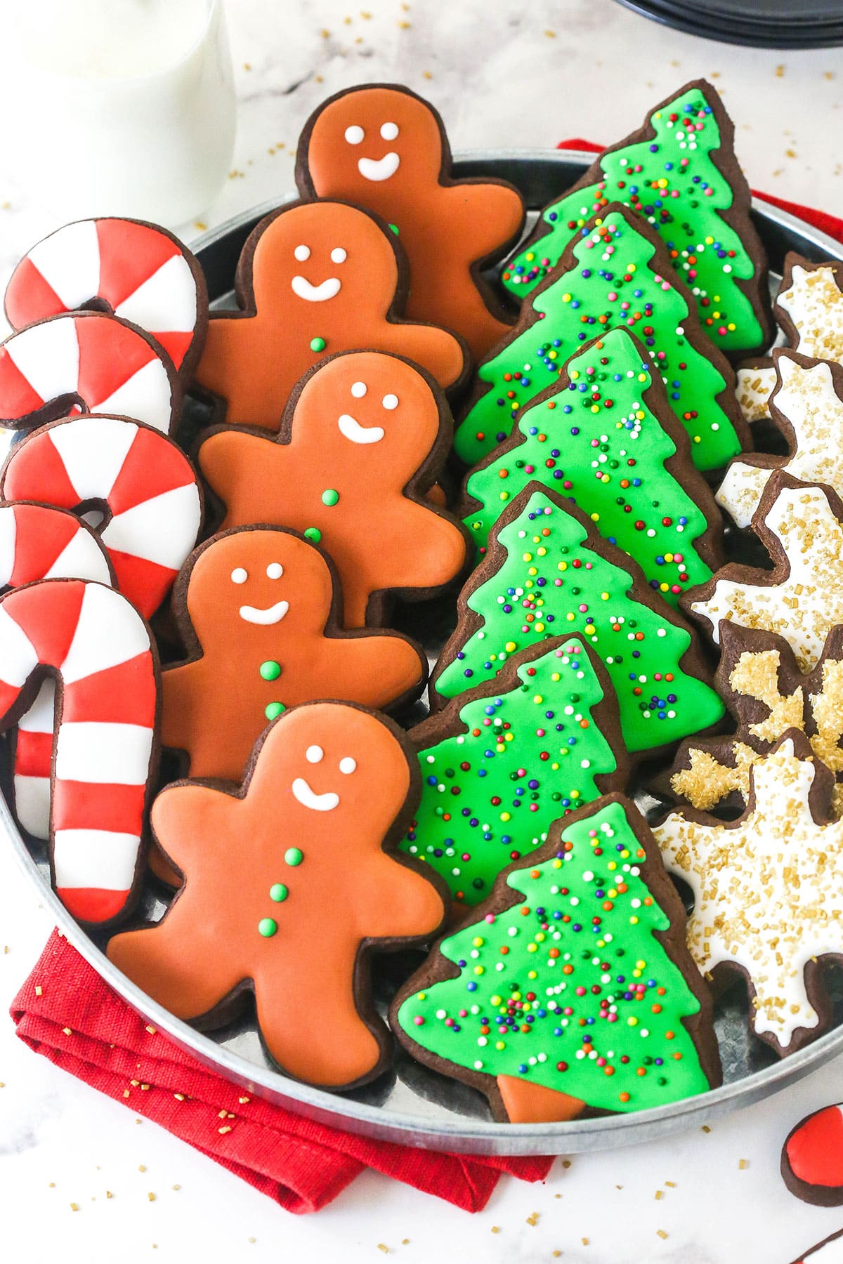 Perfectly soft and chewy, Chocolate Cut Out Cookies are easy cookies that the whole family will love. Decorate with your favorite icing. overhead view of chocolate cut out cookies decorated for Christmas on a tray