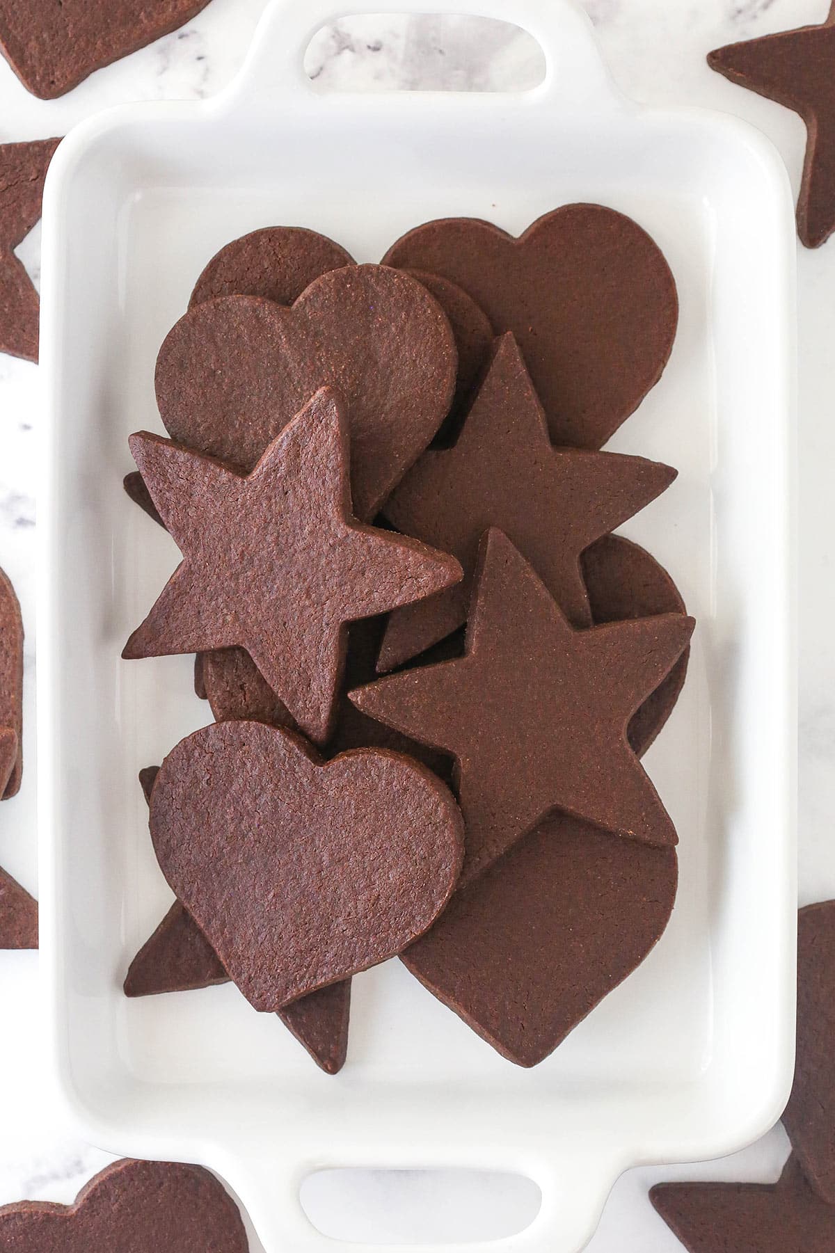 Perfectly soft and chewy, Chocolate Cut Out Cookies are easy cookies that the whole family will love. Decorate with your favorite icing. Overhead view of a tray of cutout chocolate cookies