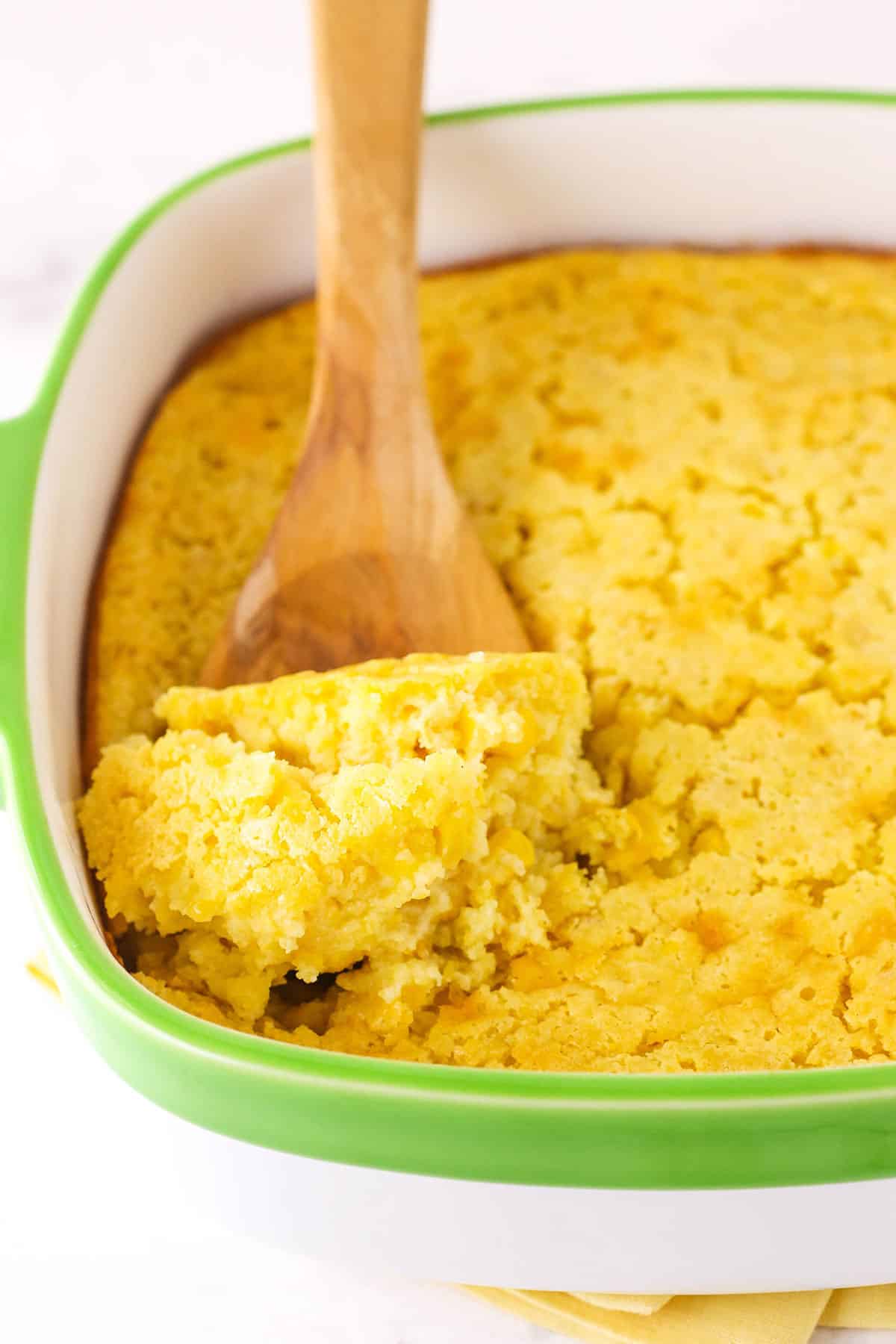 Cornbread Casserole A Wooden Spoon Scooping out a Serving of Creamy Cornbread Casserole