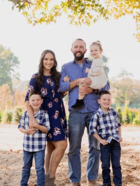 all 5 family members standing together under a tree