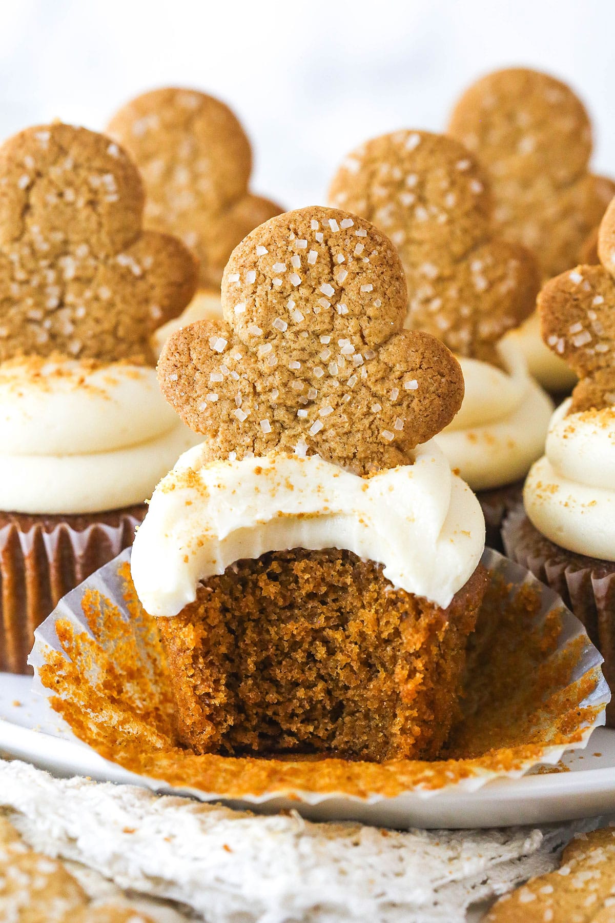These Gingerbread Cupcakes are perfectly spiced and ultra moist with a tender, fluffy crumb and topped with caramel frosting. Gingerbread cupcakes with a bite missing