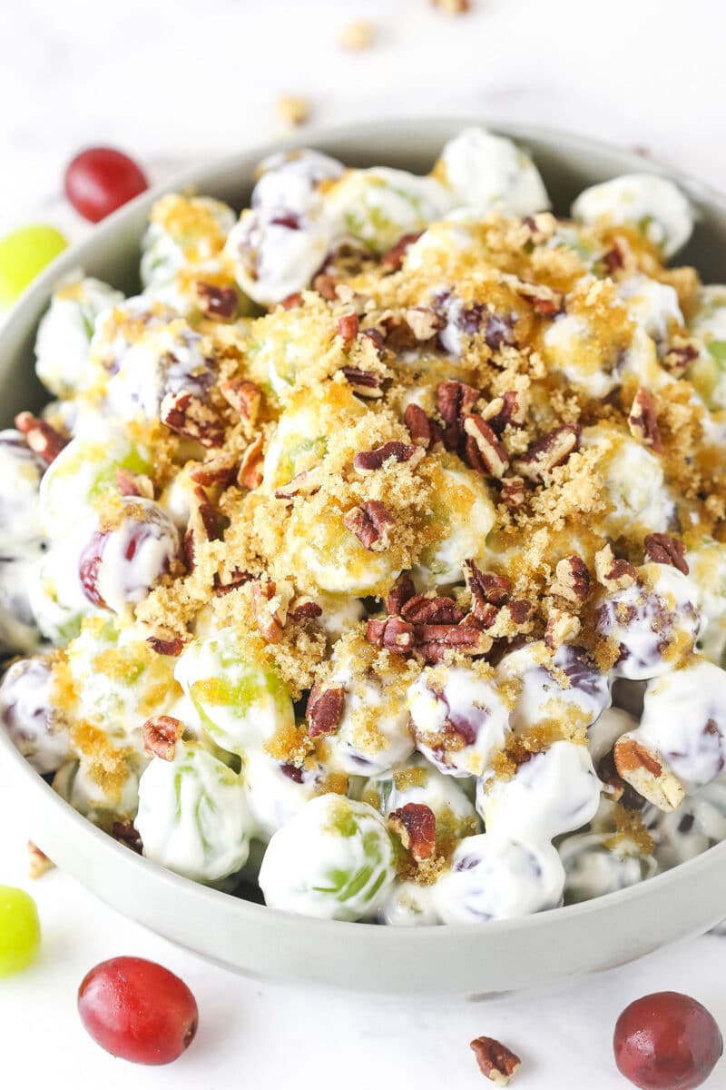 This easy grape salad recipe only takes a few minutes to put together. Red and green grapes are tossed with a simple, creamy dressing. grape salad in light grey bowl
