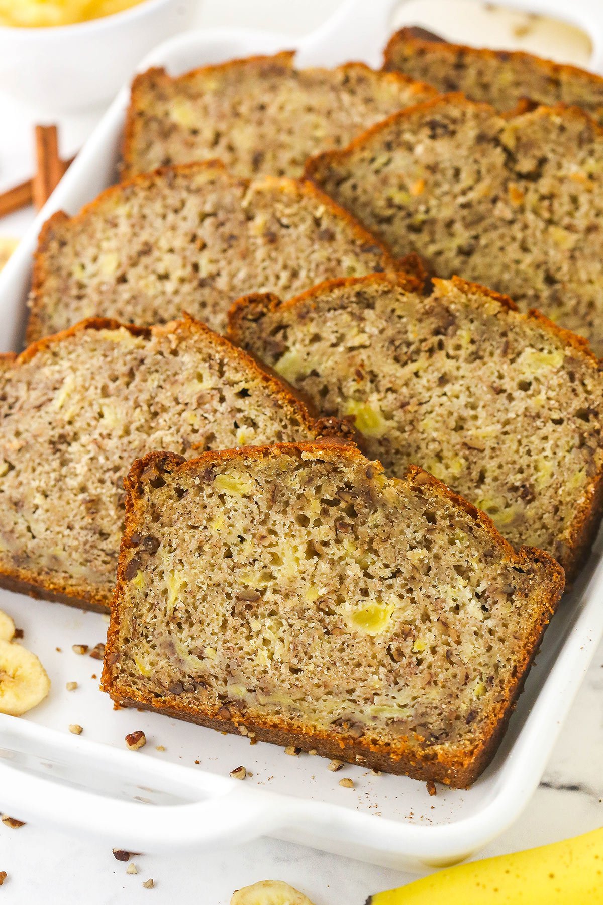 Made with mashed banana, crushed pineapple, warm spices and toasted pecans, you'll love everything about this healthy Hummingbird Bread! Seven pieces of pineapple banana bread inside of a large casserole dish