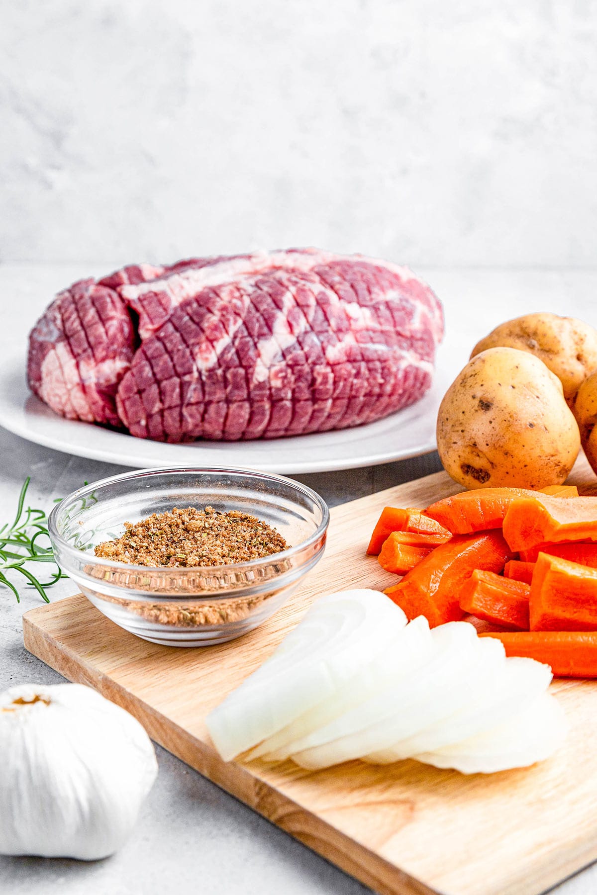 Instant Pot pork roast ingredients - pork shoulder, seasonings, onions, carrots and potatoes