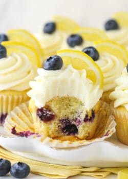 A lemon blueberry cupcake with a bite taken out of it.
