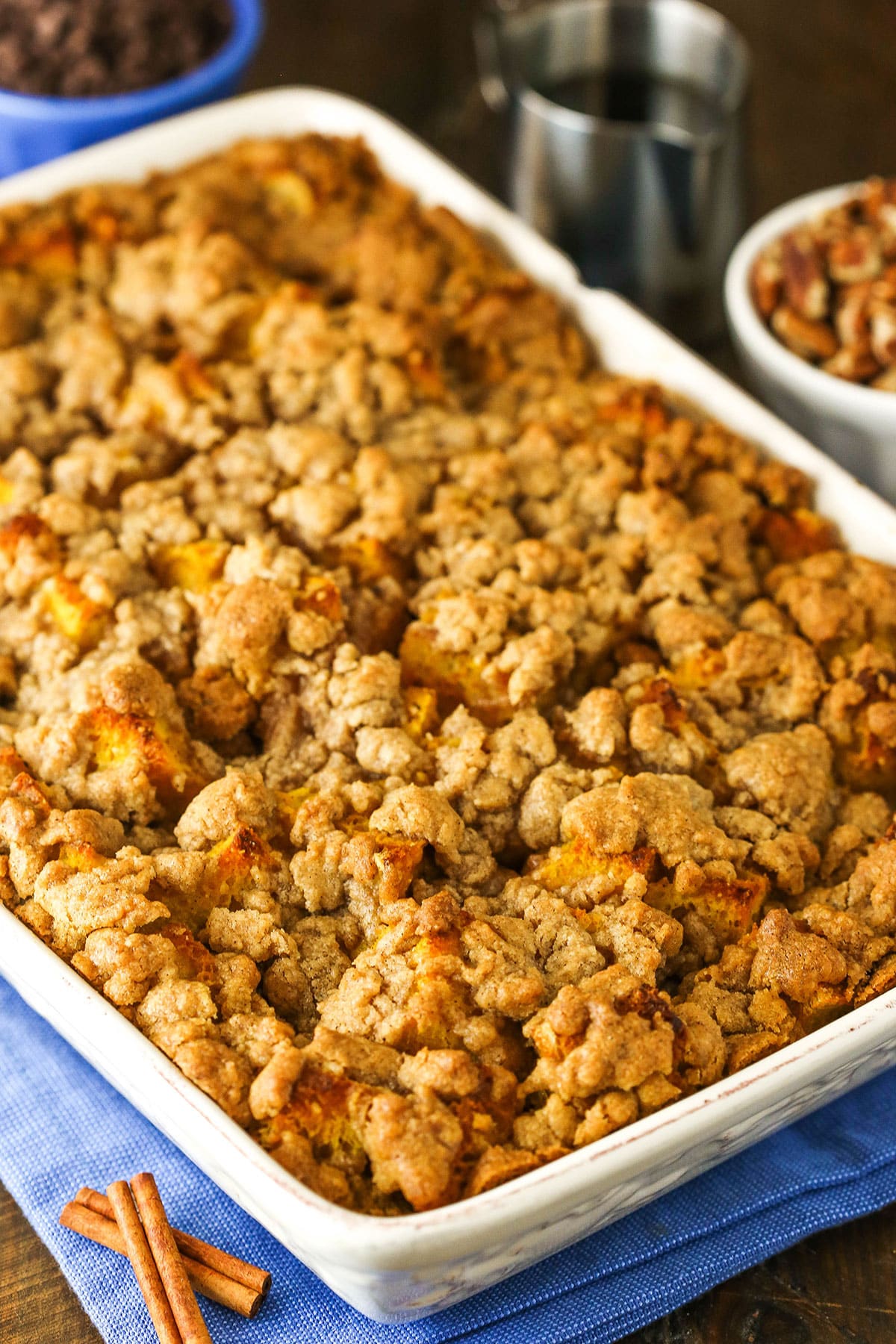With pumpkin puree and sourdough bread topped with a spiced streusel topping, Pumpkin French Toast Casserole is the perfect fall breakfast. Overhead view of a full Overnight Pumpkin French Toast Casserole in a white platter