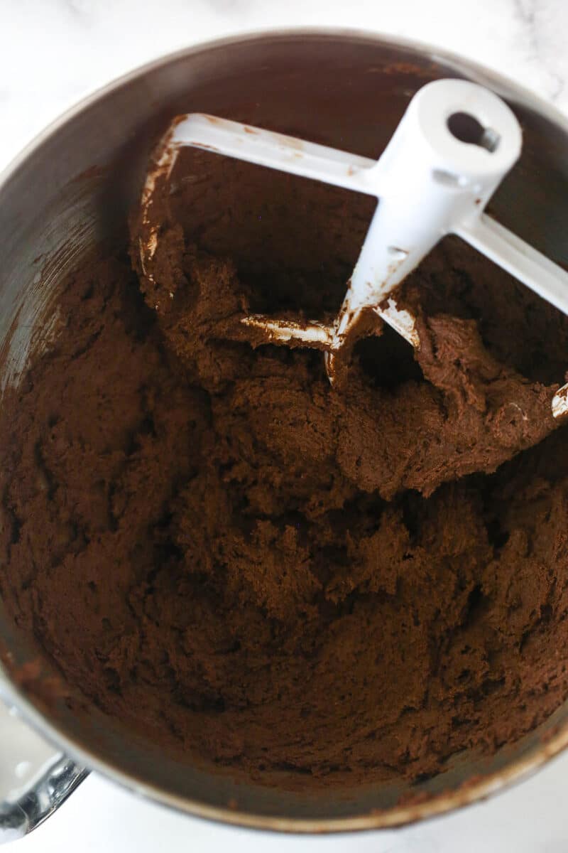 Chocolate cookie dough in a metal mixing bowl.