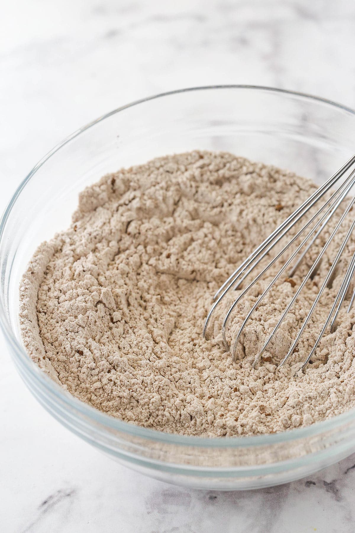 Whisking the dry ingredients in a glass bowl.