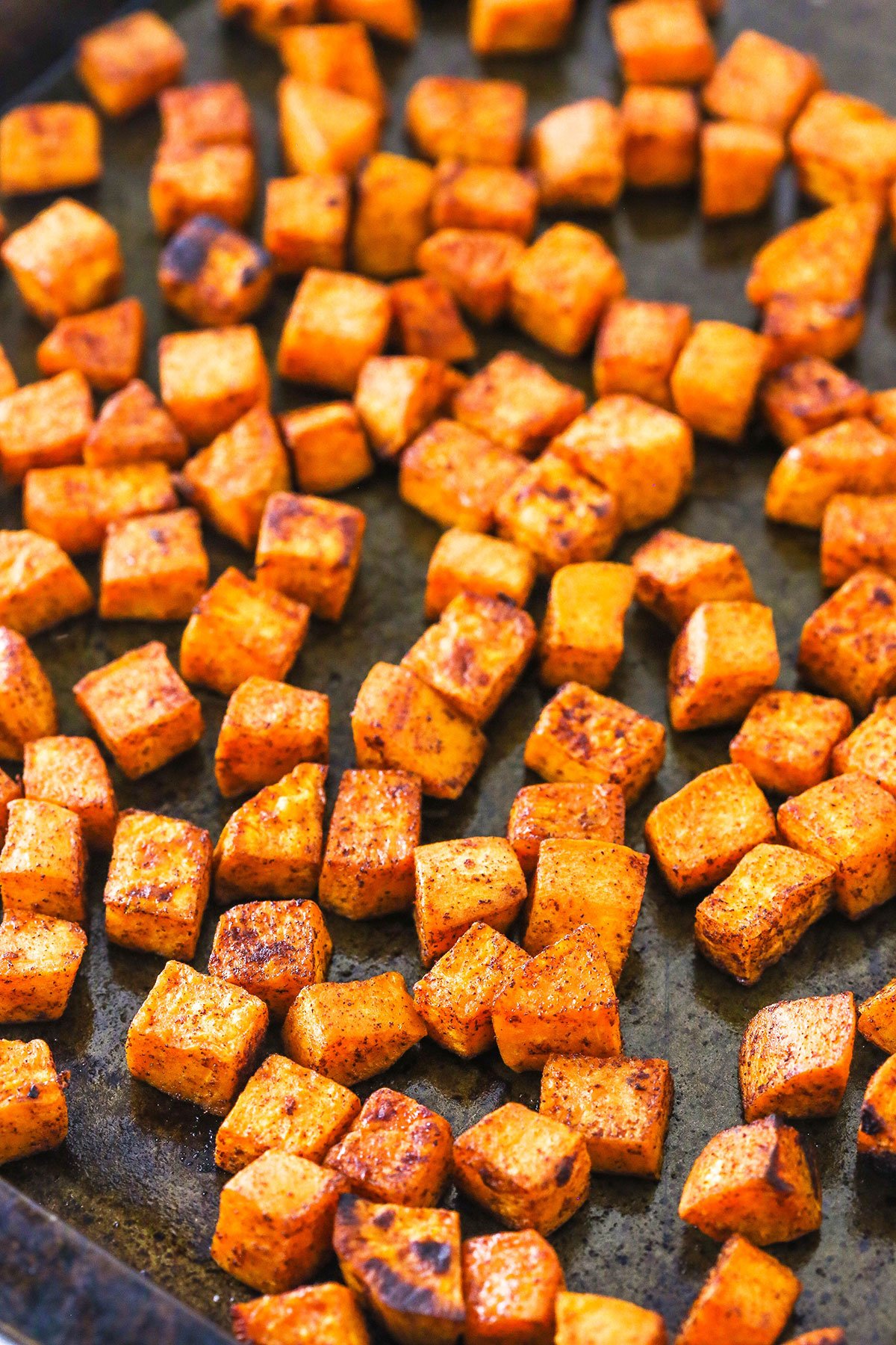 A pan full of roasted sweet potatoes with light browning.