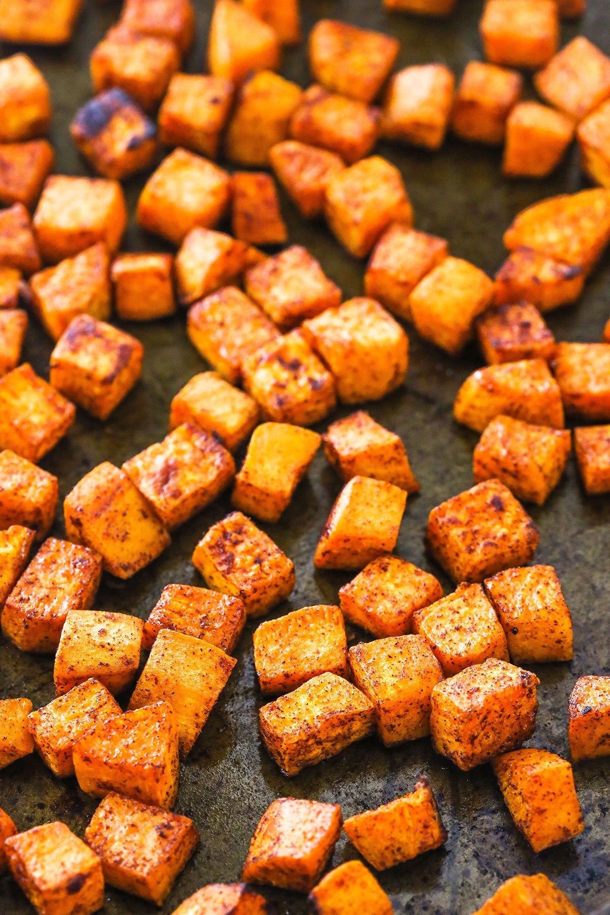 These easy roasted sweet potatoes have the perfect balance of sweet and salty. Made with just 5 ingredients and perfect for Thanksgiving! Roasted sweet potatoes arranged on a baking pan.