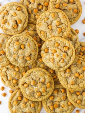 Overhead view of salted butterscotch cookies piled on a white countertop.