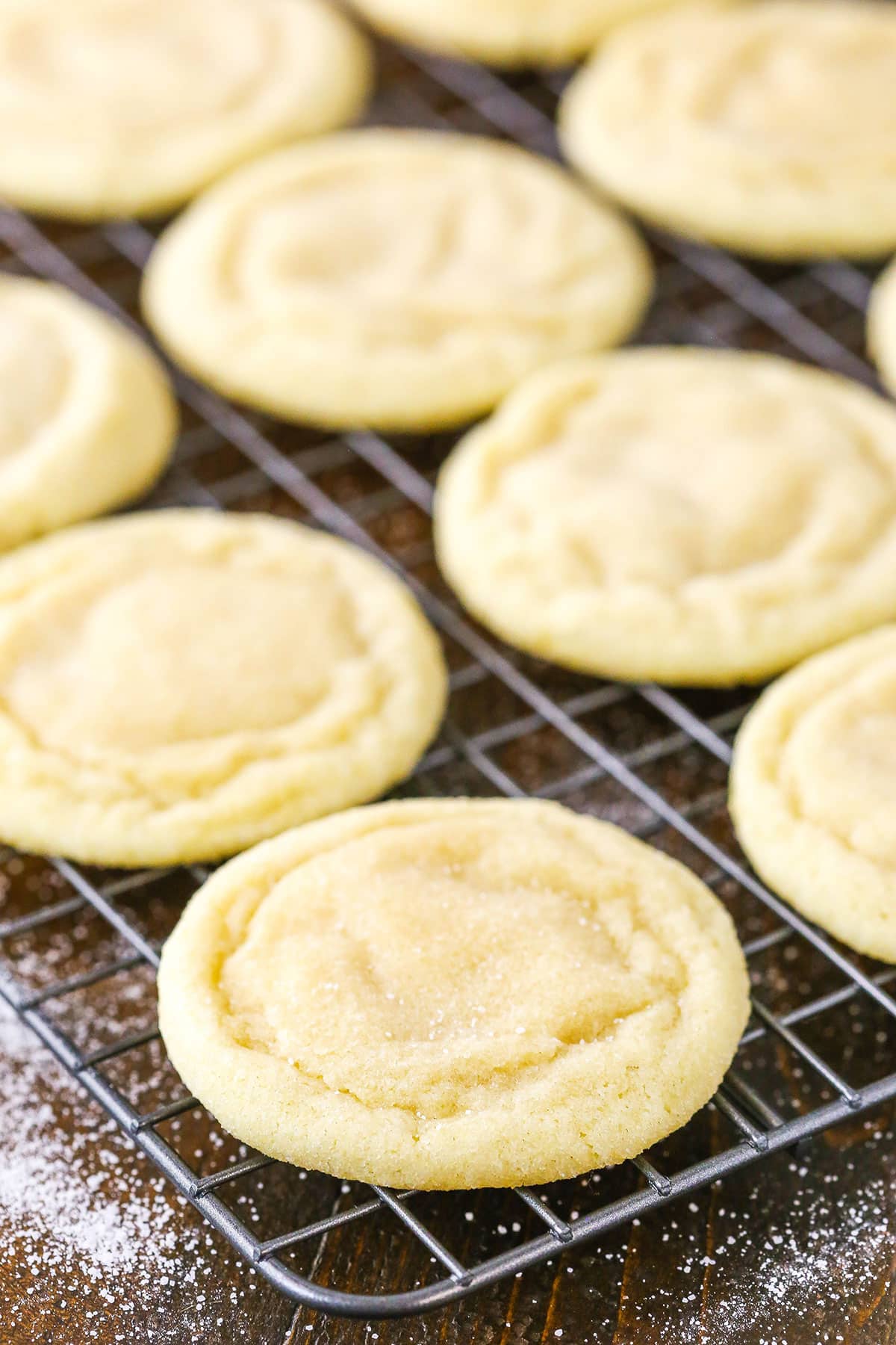 This easy sugar cookie recipe requires NO CHILLING and makes soft sugar cookies that stay chewy for DAYS! My best sugar cookies! Sugar Cookies spread out on a metal cooling rack