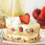 A slice of Strawberry Champagne Tiramisu on a white plate and pink napkin.