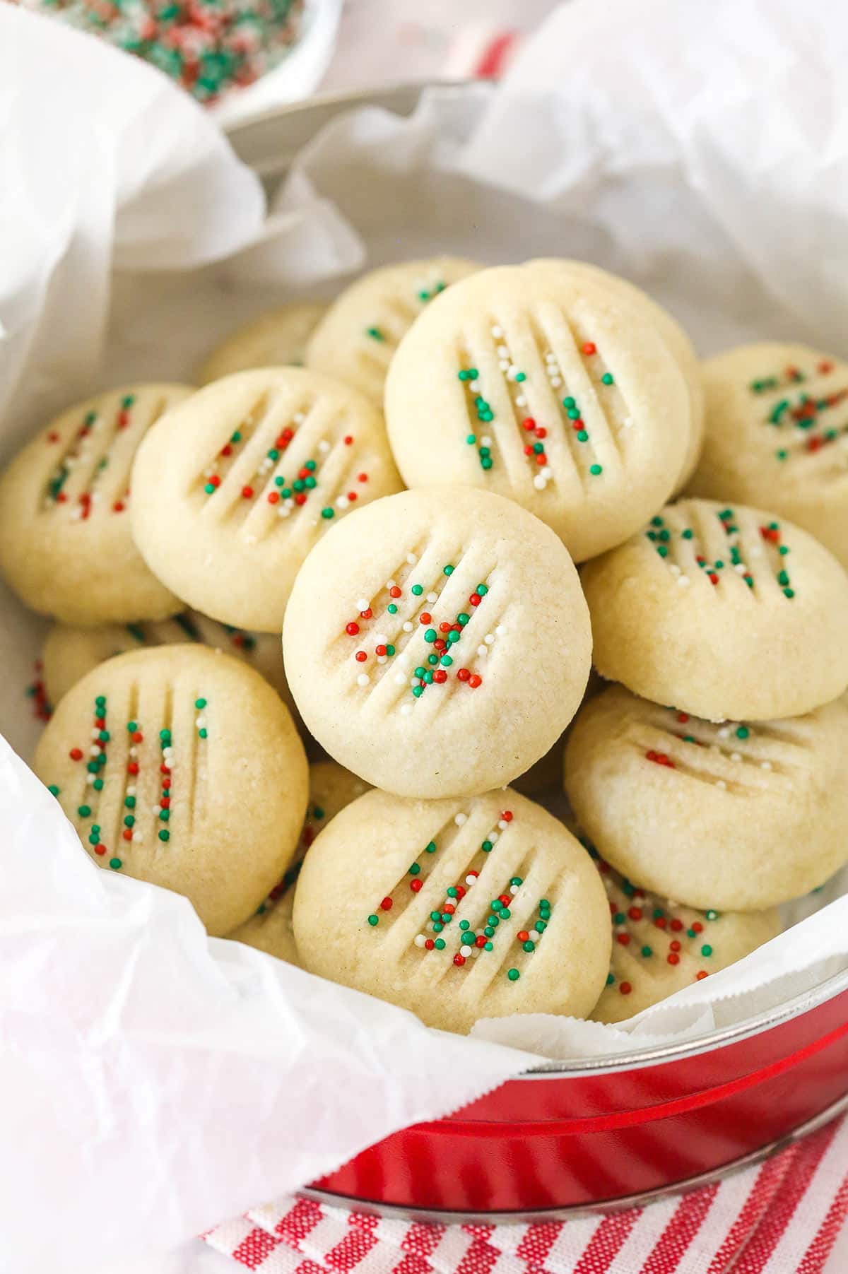 Made with just 5 ingredients, these Whipped Shortbread Cookies are so tender and buttery that they almost melt in your mouth. Overhead view of a tin of Christmas whipped shortbread cookies